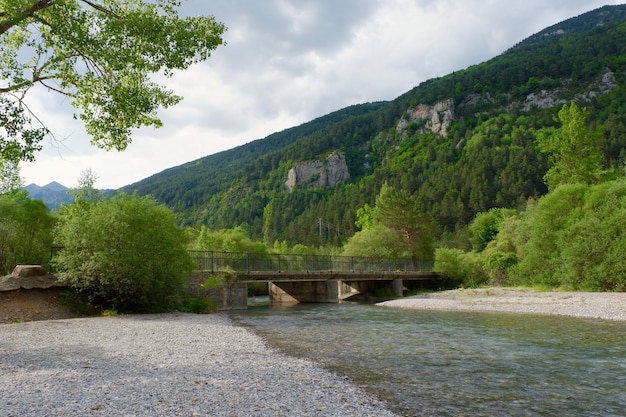 Paisagem de montanha vibrante ponte velha rio Barrosa verão Parque Nacional dos Pirenéus Bielsa Espanha