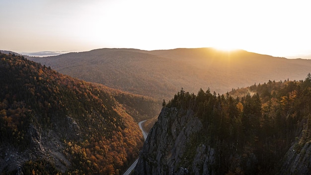 Paisagem de montanhas rochosas com florestas durante o pôr do sol