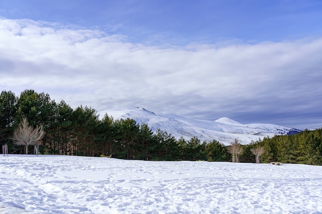 Paisagem de neve na montanha de Madrid com sol, céu azul e alta montanha. Morcuera.