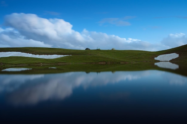 Paisagem de noite na primavera. Lago da Montanha. Reflexo das nuvens na água. lago Koruldi, cume caucasiano principal. Zemo Svaneti, Geórgia