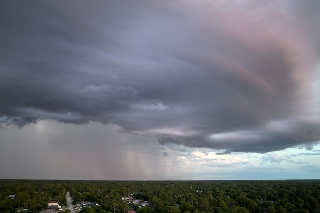 Paisagem de nuvens escuras e sinistras se formando no céu tempestuoso durante forte tempestade sobre a área rural da cidade ao pôr do sol