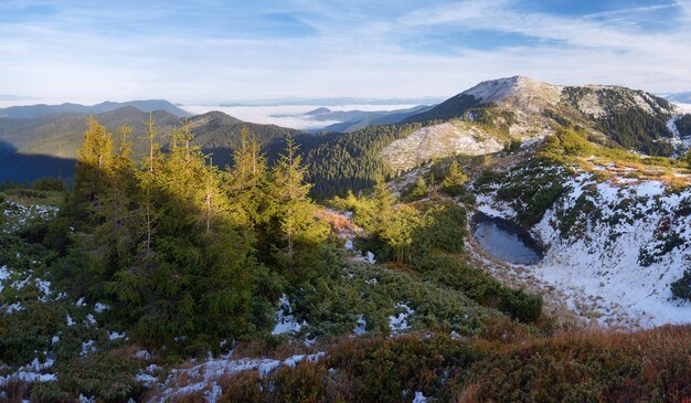 Paisagem de Outono com árvores spruce. Mountain Lake. Primeira neve na entressafra. Cárpatos, Ucrânia, Europa