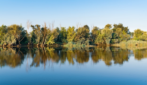 Paisagem de um grande lago silencioso com água fria tranquila em dia de verão