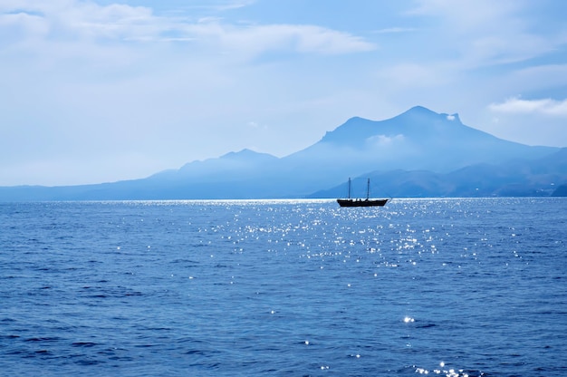 Paisagem de verão com mar, barco e cordilheira