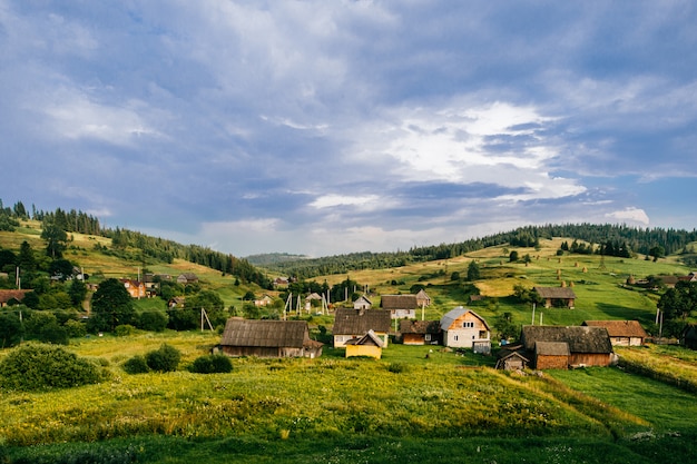 Paisagem de verão com vila nas montanhas.