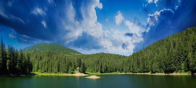 Paisagem de verão das montanhas dos Cárpatos com lago Sinevir e panorama de fundo natural dramático do céu nublado