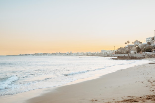 Paisagem de verão na praia ao pôr-do-sol areia marrom sedosa com ondas rolando na praia cópia de bandeira