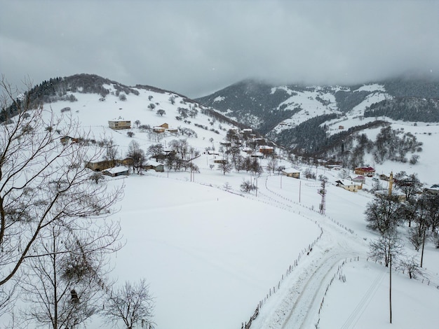 Paisagem do inverno com pequenas casas de aldeia entre a floresta coberta de neve em montanhas frias Giresun Turquia