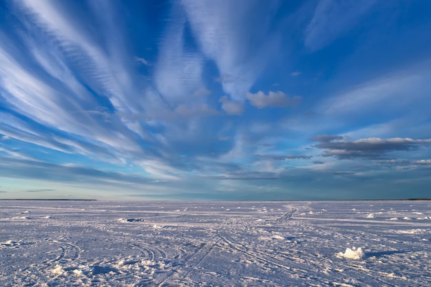 Paisagem do inverno com rio no gelo e neve com céu azul e nuvens brancas