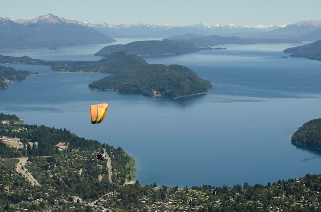 Paisagem do lago bariloche e montanhas com parapente voando para o topo