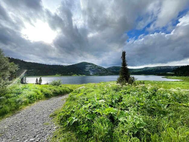 Paisagem do lago de montanha selvagem no verão. Picos de montanhas ao redor do lago. Conceito de natureza selvagem.