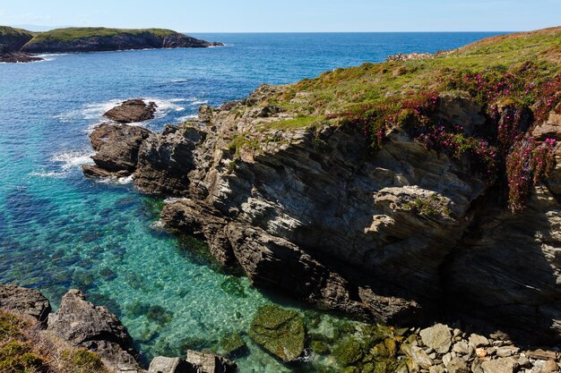 Paisagem do litoral de Pancha da ilha do oceano do verão com farol (Espanha).