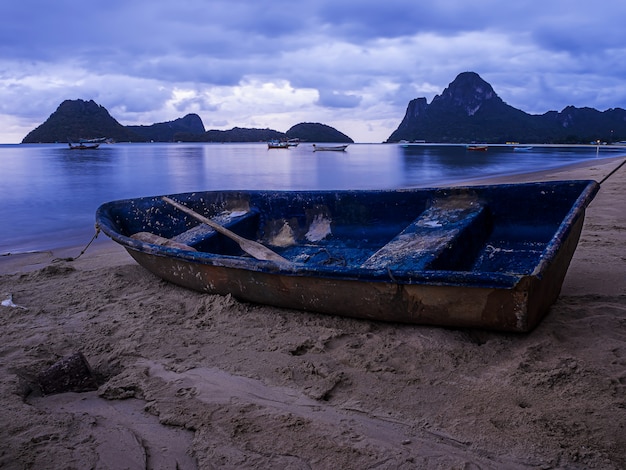 Paisagem do mar e pequeno barco na hora do crepúsculo, tailândia