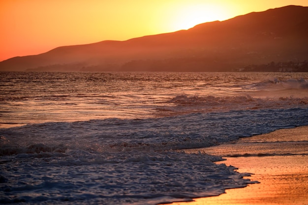 Paisagem do mar e praia tropical ao pôr do sol ou nascer do sol para viagens de lazer e férias Reflexo do sol na água e areia na praia