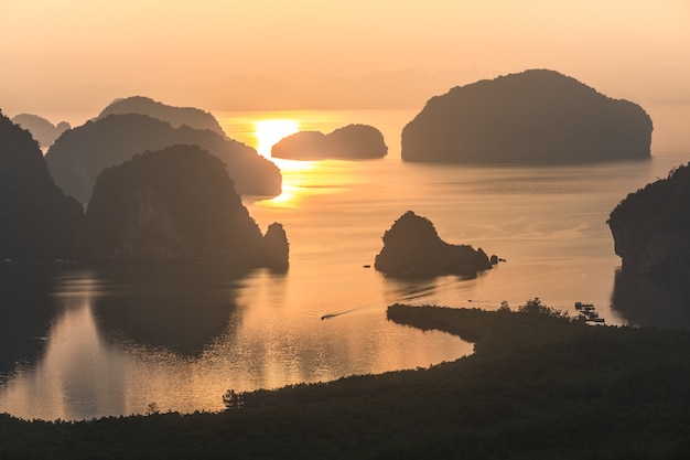 Foto paisagem do nascer do sol em carsts da pedra calcária na baía de phang nga no nascer do sol. lugar invisível de