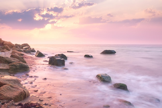 Paisagem do nascer do sol sobre a bela costa rochosa no mar