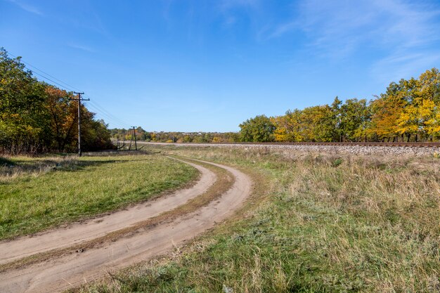 Paisagem do outono com estrada de ferro e país