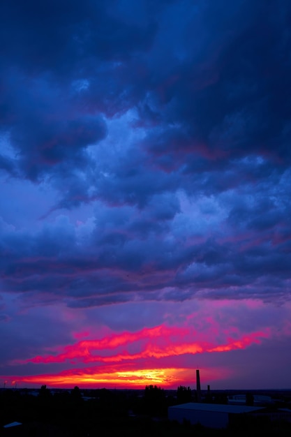 Paisagem do pôr do sol de verão ardente sol alaranjado e céu azul escuro