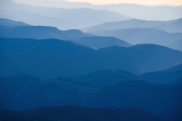 Paisagem do pôr do sol de verão das montanhas dos Cárpatos com gradiente abstrato de picos de montanha em cores azuis, viagens naturais ao ar livre