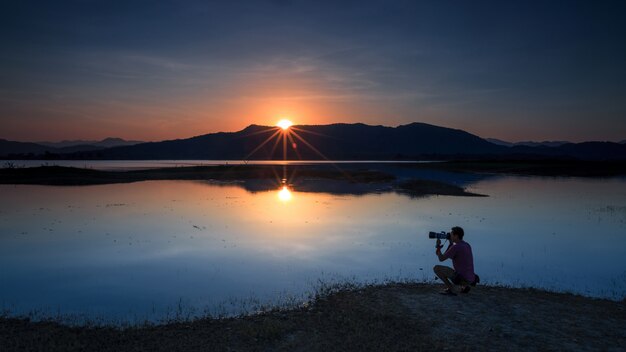 Paisagem do pôr do sol e fotógrafo