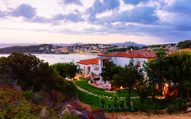 Paisagem e cenário do resort de luxo Baja Sardinia na Costa Smeralda ao pôr do sol, ilha da Sardenha, na Itália, no verão. província de Ólbia. Villas e mar Mediterrâneo