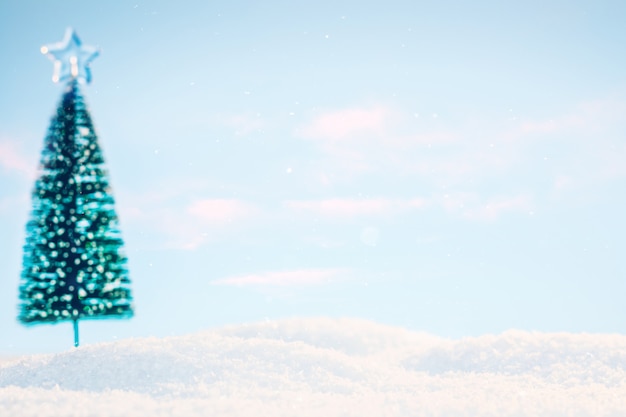 Paisagem ensolarada com neve e uma árvore de Natal