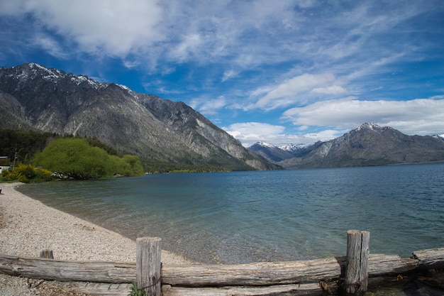 Paisagem idílica da Patagônia Argentina. Lago entre montanhas, praia, vegetação e céu nublado.