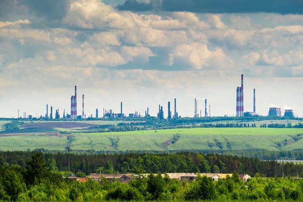 Paisagem industrial com uma refinaria de petróleo na colina verde