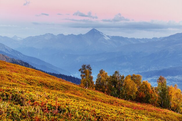 Paisagem mágica de outono e picos de montanhas cobertas de neve. Vista de t