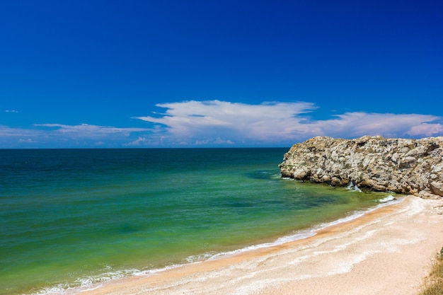 Paisagem marinha praia de areia no mar e rochas na costa em um dia claro