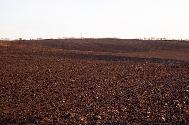 Paisagem marrom montanhosa do campo, campo agrícola da mola.