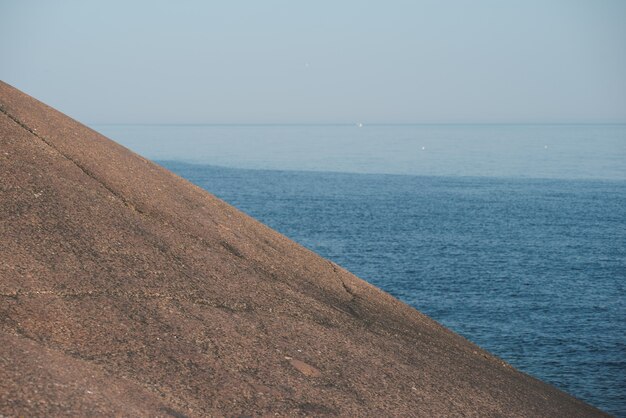 Paisagem minimalista. Declive da rocha. Mar ao fundo