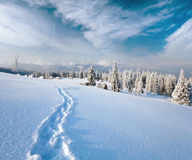 Paisagem montanhosa calma de inverno com grupo de galpões e cume de montagem atrás das montanhas Kukol Mount Carpathian Ucrânia