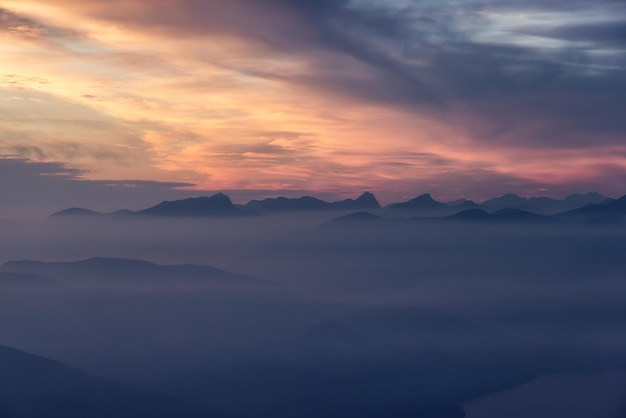 Paisagem montanhosa canadense na costa oeste do pôr do sol dramático do Oceano Pacífico e céu nebuloso e esfumaçado