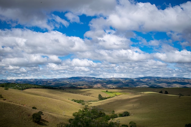 Paisagem montanhosa, colinas e céu azul com nuvens brancas