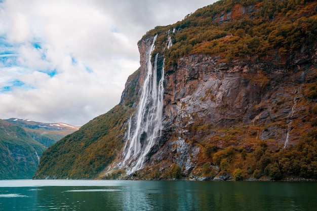 Paisagem montanhosa com céu nublado Bela natureza NoruegaGeiranger fjord Seven Sisters Waterfall