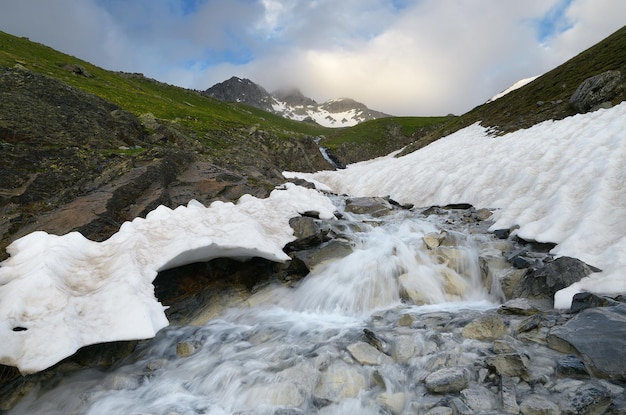 Paisagem montanhosa com um rio de gelo. Dia nublado. Zemo Svaneti, Geórgia