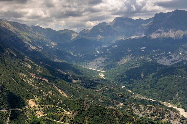 Paisagem montanhosa com vista para o vale da floresta e o rio Kalarrytikos em uma região de dia de verão nublado Tzoumerka Grécia montanhas Pindos