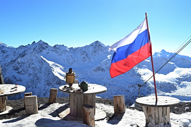 Foto paisagem montanhosa de inverno, bandeira russa, samovar e cafés nas montanhas