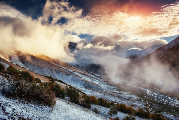 Paisagem montanhosa de montanhas cobertas de neve na névoa