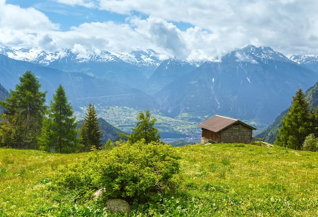 Paisagem montanhosa de verão com neve no topo do monte e casa na encosta (Alpes, Suíça)