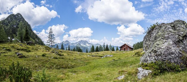 Paisagem montanhosa idílica nos alpes Prados de chalé de montanha e céu azul