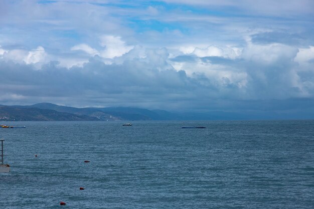 Paisagem montanhosa turva dramática na praia do Mar Negro, paisagem com nuvens e céu, refletida na água.