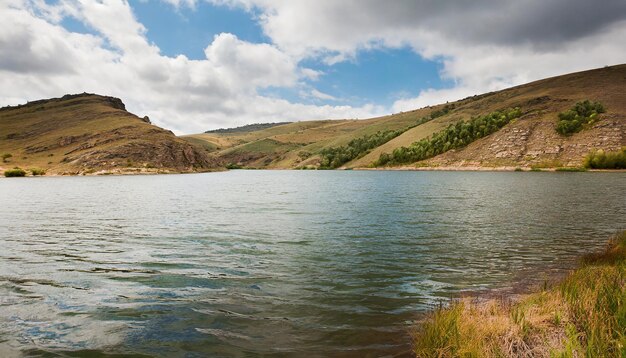 paisagem natural com um lago calmo, colinas e céu nublado