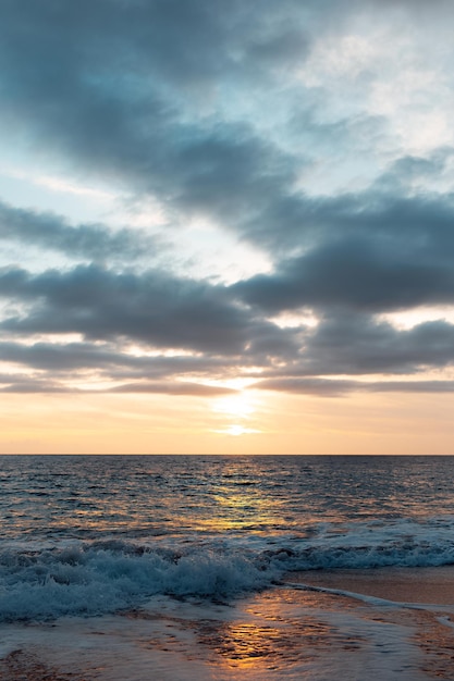 Paisagem natural do belo pôr do sol e ondas do mar Mediterrâneo na costa de Chipre Foto vertical