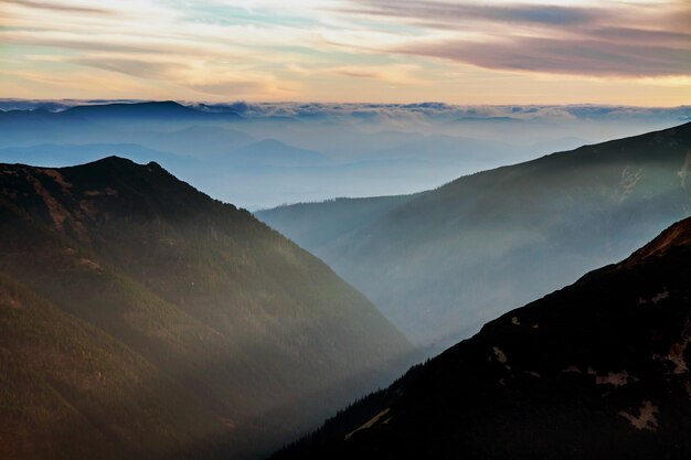 Paisagem nevoenta do horizonte do pôr do sol da montanha em Zakopane