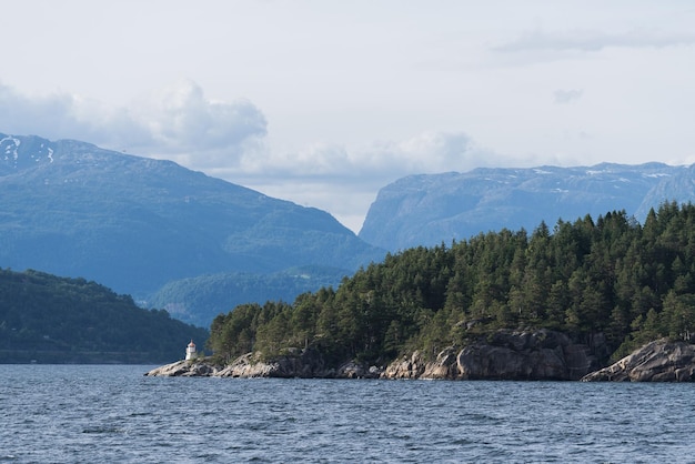 Paisagem norueguesa de verão com um farol na costa do fiorde