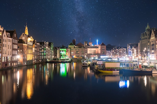 Paisagem noturna com casas e canal em amsterdã