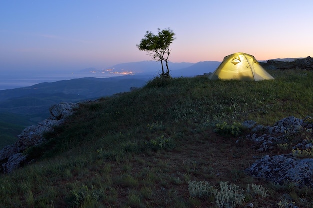 Paisagem noturna com tenda turística. Acampar nas montanhas