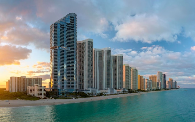 Paisagem noturna de areia à beira-mar na cidade de Sunny Isles Beach, com hotéis luxuosos e prédios de condomínios na costa do Oceano Atlântico, infraestrutura turística americana no sul da Flórida